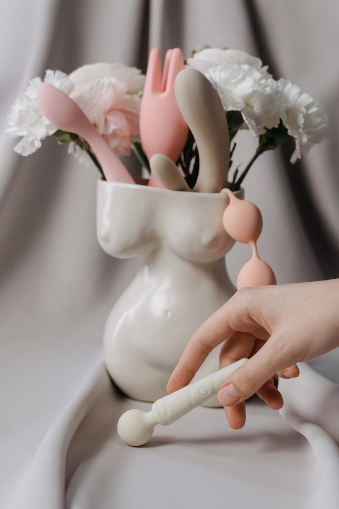 une vase en forme du corps de femme remplie de fleure et de jouets sexuels